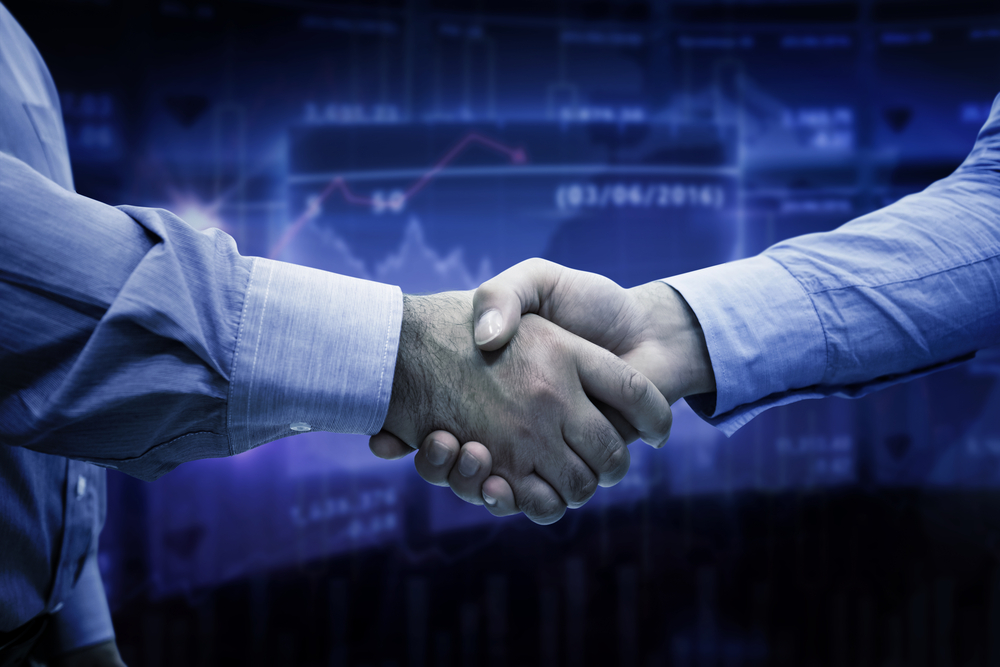 A handshake against a blue graph background to signify business deals and how to address your customers' data security requirements
